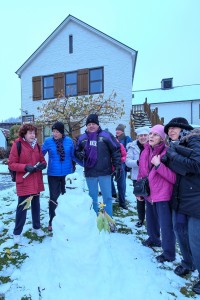 The image shows our group around a snowman we built in front of the Queenstown police station